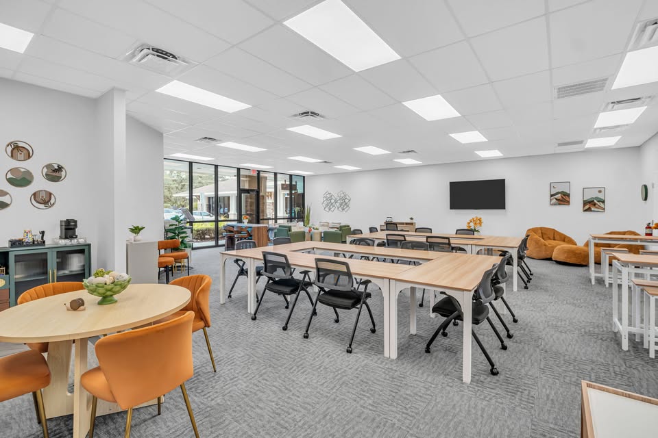 Bright classroom at Let'sCo! Oldsmar with tables arranged for hands-on laptop work
